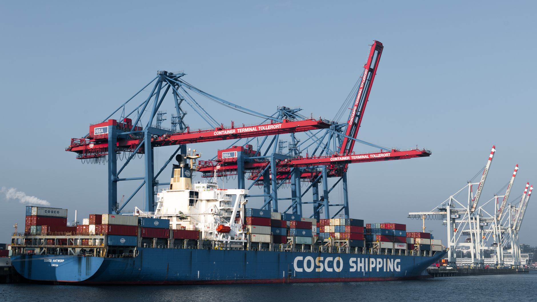 Large cargo ship docked at an industrial port terminal during loading operations