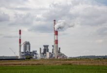 Industrial smokestack emitting gases against a cloudy sky, representing sulfur dioxide emissions from power plants