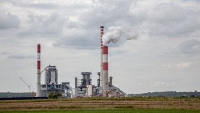 Industrial smokestack emitting gases against a cloudy sky, representing sulfur dioxide emissions from power plants
