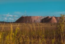 Open-pit bauxite mine with heavy excavation equipment and exposed red ore deposits