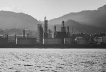 Large oil refinery facility with processing towers and pipelines representing sulfur byproduct production