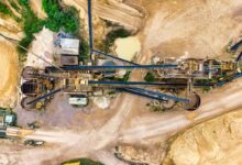 Aerial view of an open-pit rare earth mining operation with heavy equipment