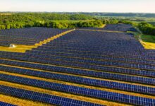 Aerial view of a large utility-scale solar farm on agricultural land