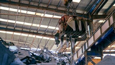 Workers inside a titanium metal processing facility with industrial equipment
