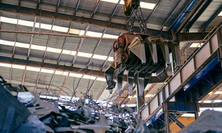 Workers inside a titanium metal processing facility with industrial equipment