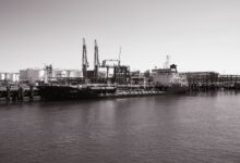 Large industrial oil storage terminal with tanks and port infrastructure
