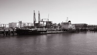 Large industrial oil storage terminal with tanks and port infrastructure