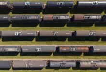 Industrial tank rail cars lined up on freight tracks at a rail yard