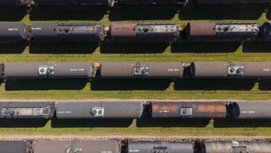 Industrial tank rail cars lined up on freight tracks at a rail yard