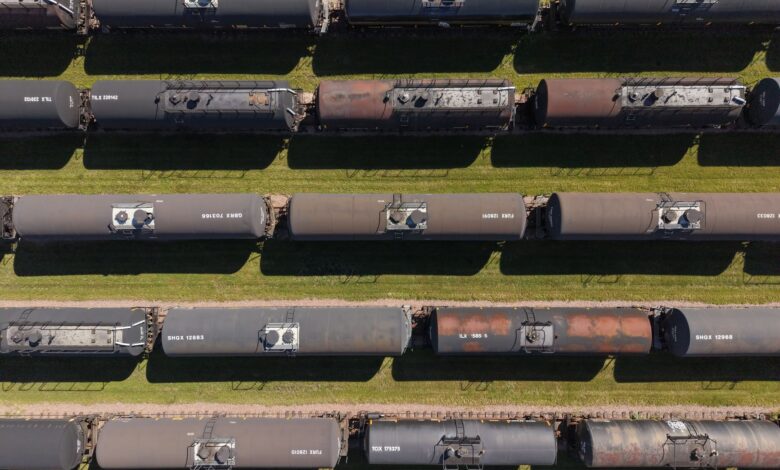 Industrial tank rail cars lined up on freight tracks at a rail yard