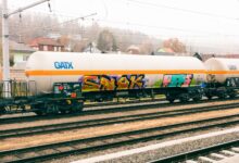 A row of industrial tank rail cars on a freight rail line used for chemical transport