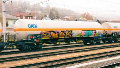 A row of industrial tank rail cars on a freight rail line used for chemical transport