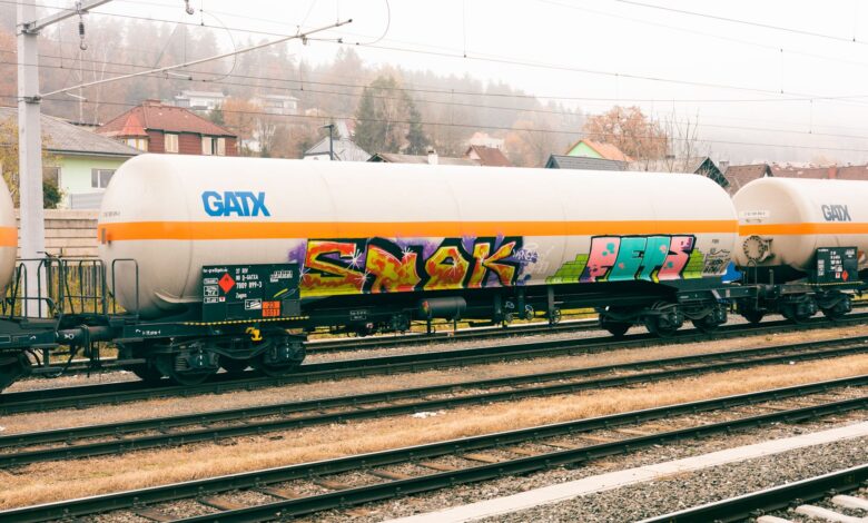A row of industrial tank rail cars on a freight rail line used for chemical transport