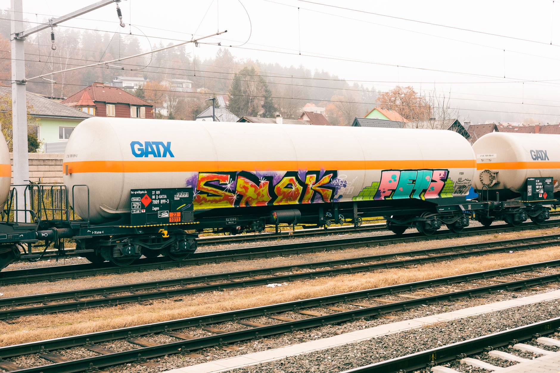 A row of industrial tank rail cars on a freight rail line used for chemical transport