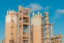 Large industrial chemical plant with pipes and processing towers at dusk