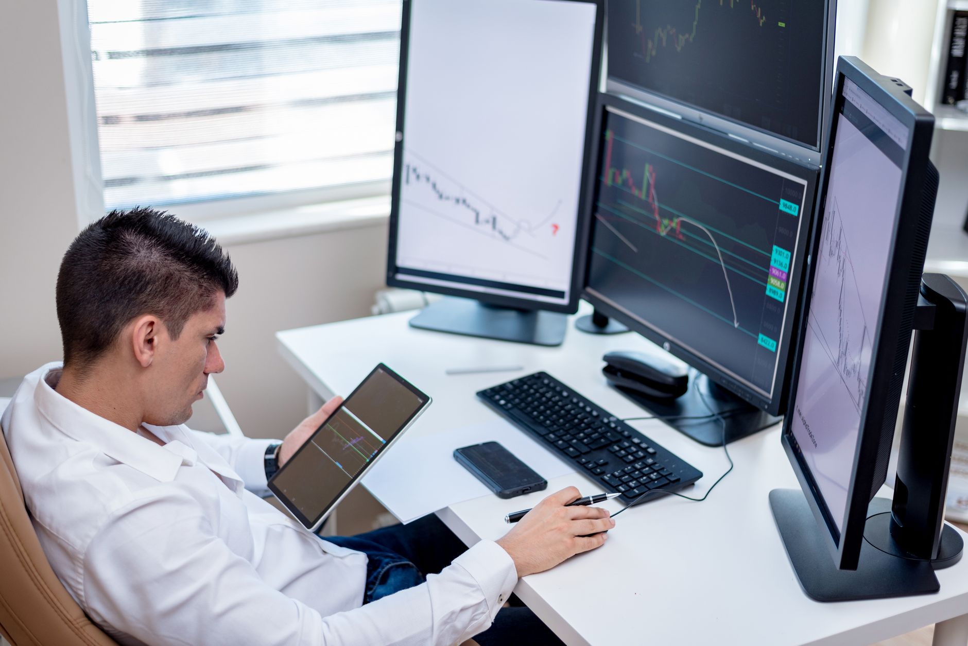 Financial trading desk with multiple screens showing market data, representing environmental commodity trading activity