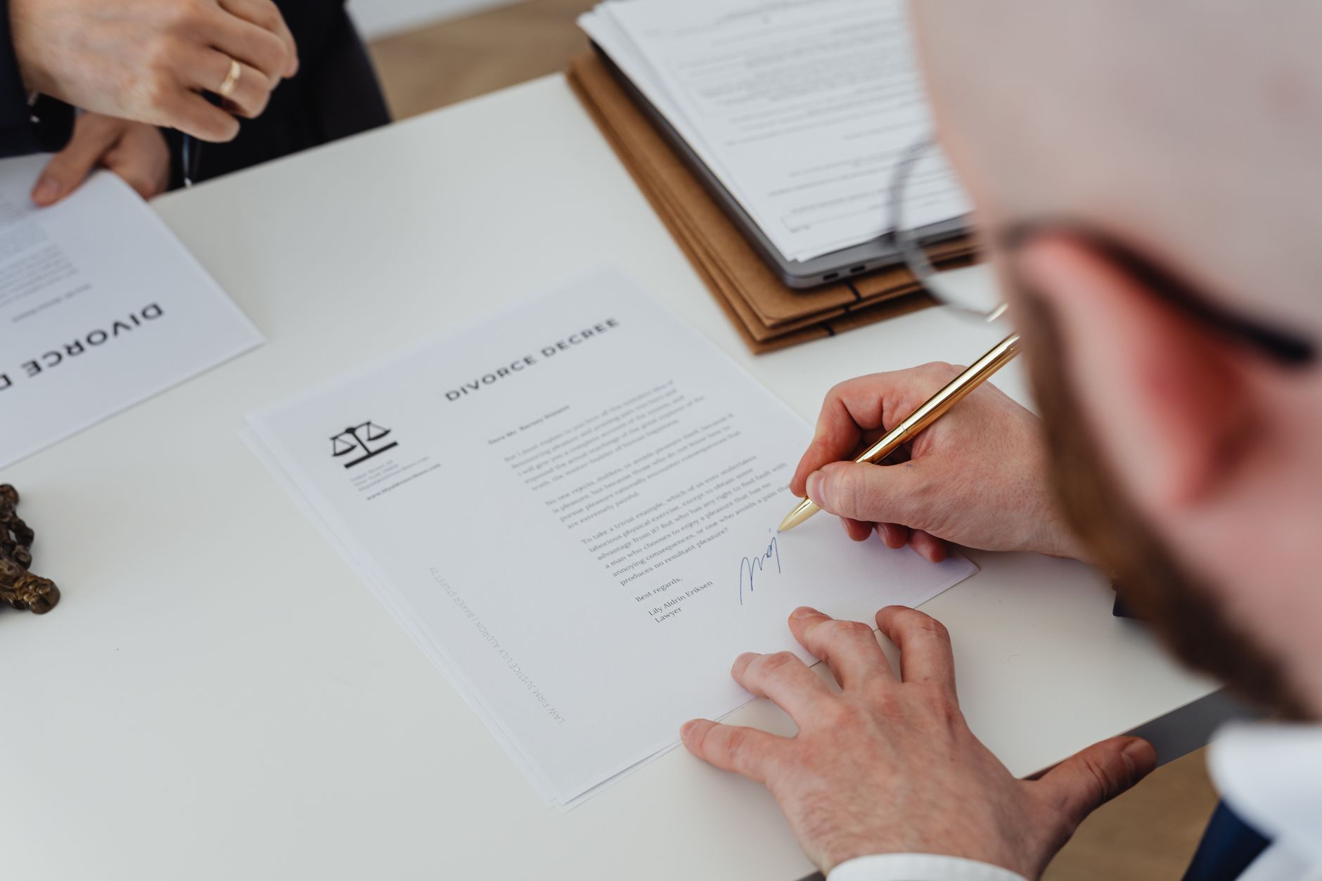 Business professionals reviewing and signing a legal agreement at a desk