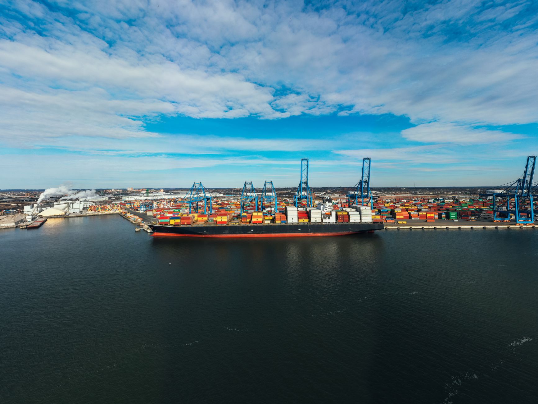 Aerial view of a commercial shipping port with cargo vessels docked