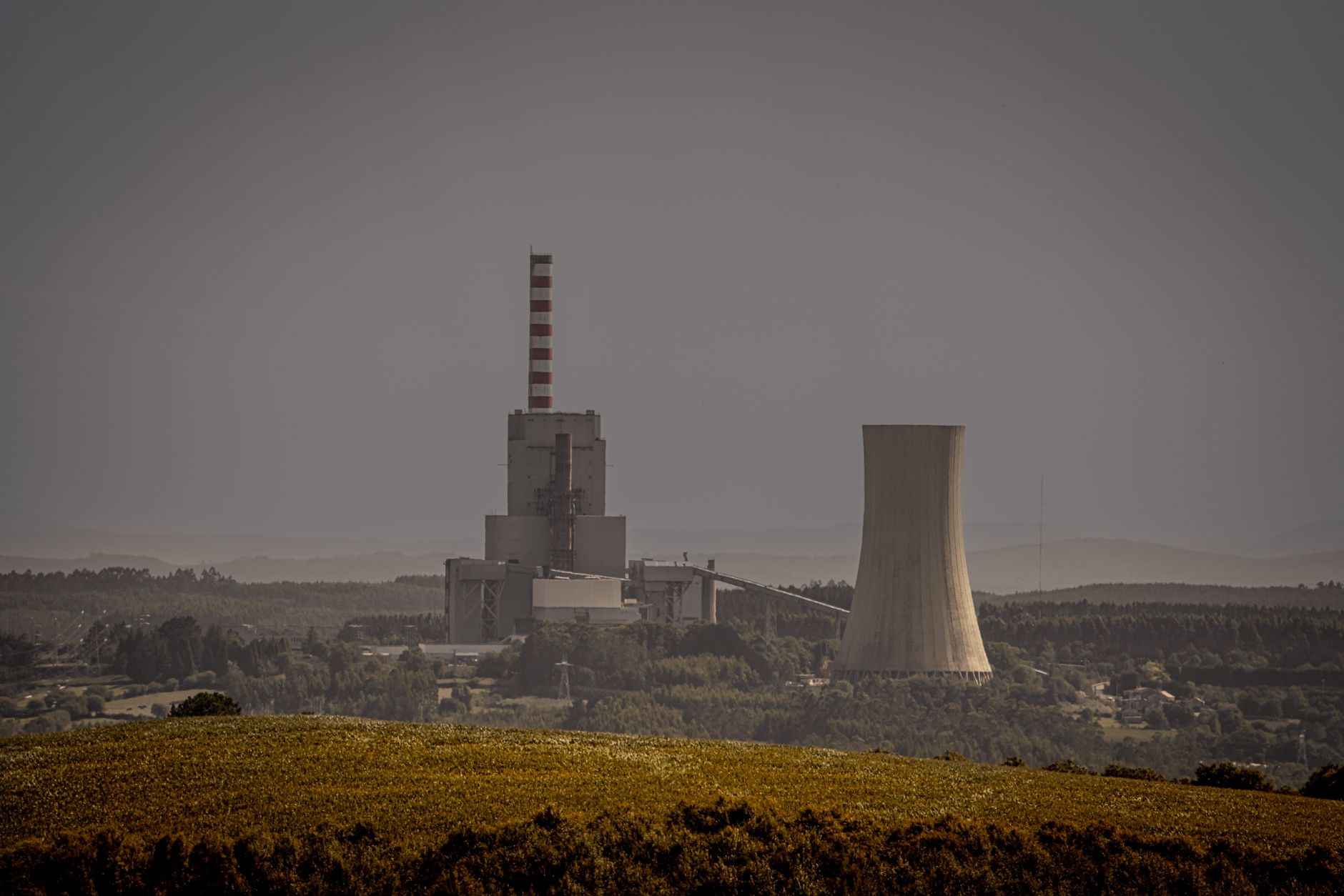 Coal-fired power plant reflected in water, illustrating the industrial sources subject to SO2 emission compliance requirements